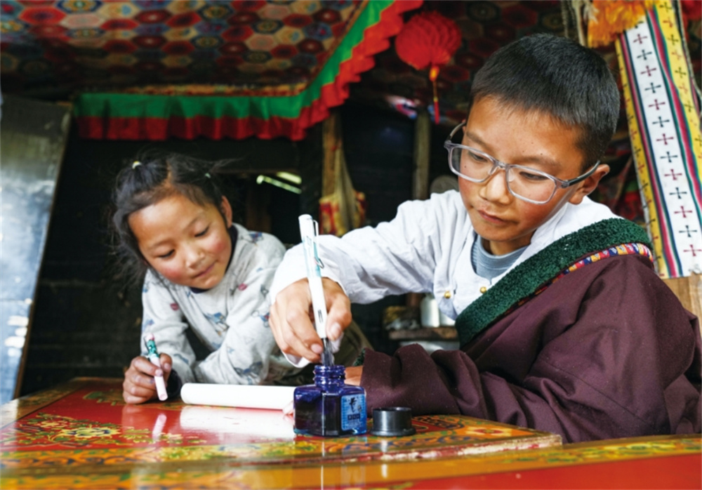 贡乔热旦（左）教表妹学习藏文书法。晋美多�? �?.jpg