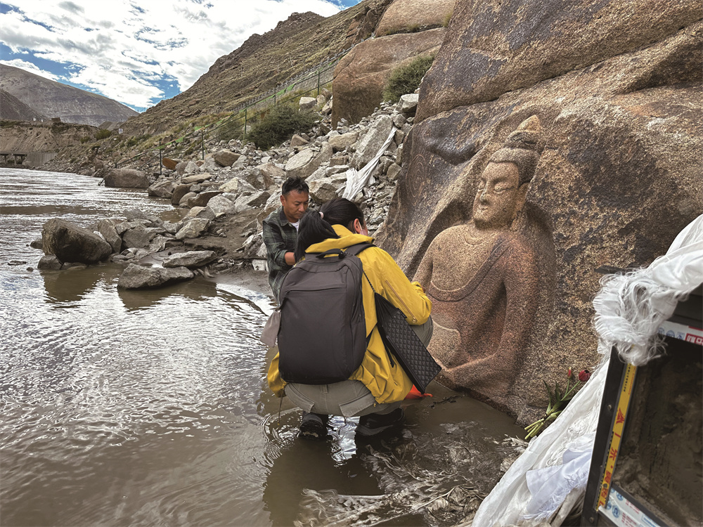 拉萨市文物普查队员次仁多吉�?�益西曲珍对热东摩崖造像进行数据采集。图：次仁多�?.jpg